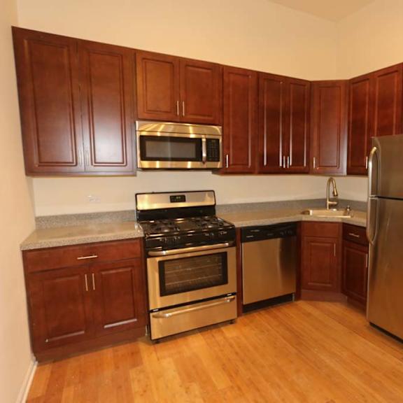 a kitchen with wooden cabinets and stainless steel appliances.
