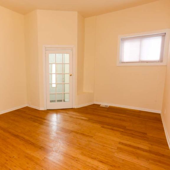 a room with wooden floors and a white door.