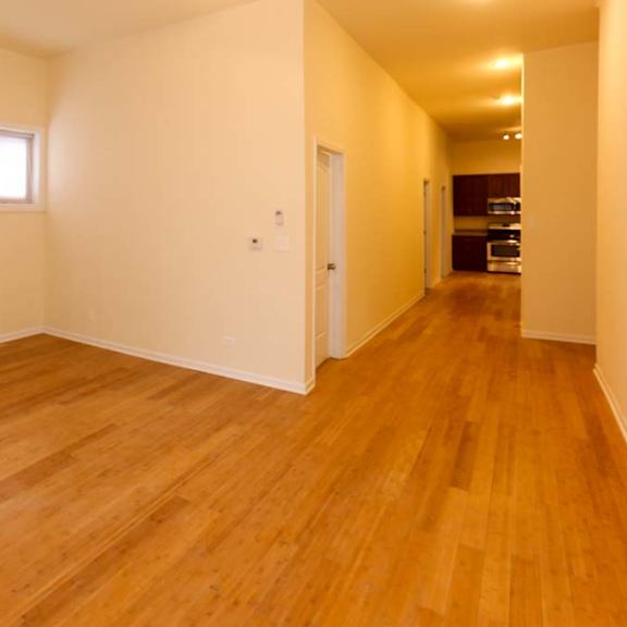 a long hallway with wooden floors and white walls.