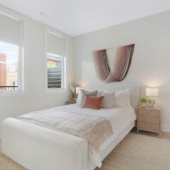 a bedroom with a large bed and a window with a view of a building outside.