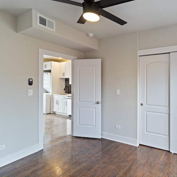 a room with a ceiling fan and white walls.