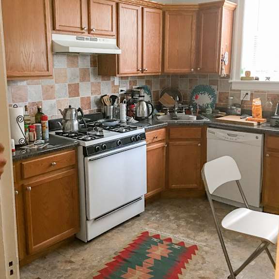 a kitchen with wooden cabinets and a white stove top oven.