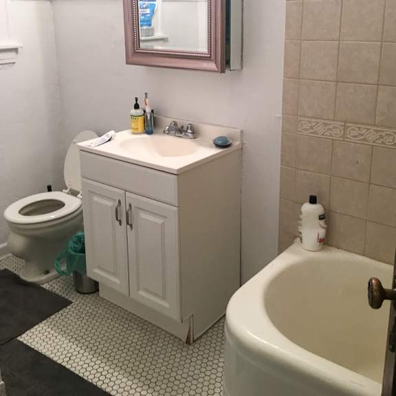 a white bathroom with a toilet, sink, and bathtub.