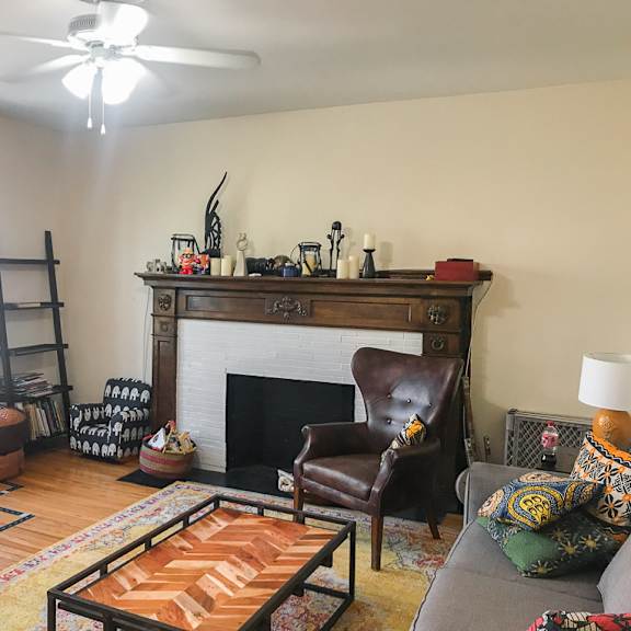 a living room with a fireplace and a brown leather chair.