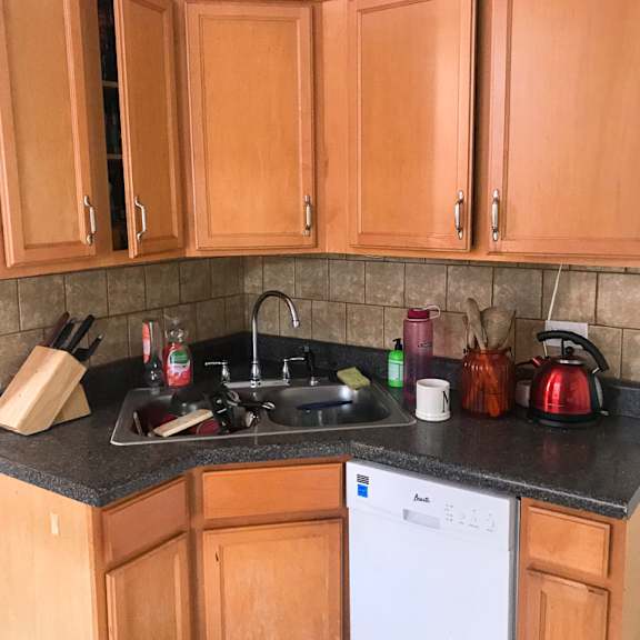 a kitchen with wooden cabinets and a white dishwasher.
