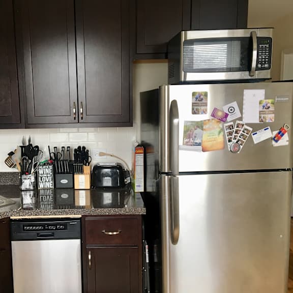 a kitchen with a stainless steel refrigerator and a microwave above it.