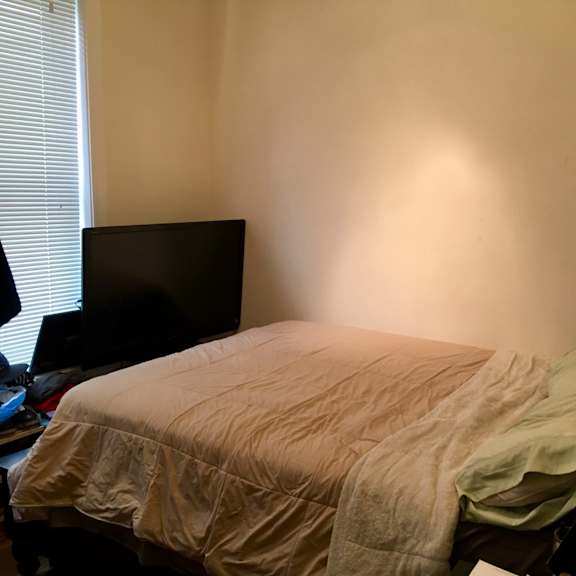 a bed with a blanket and a pillow is in the room.