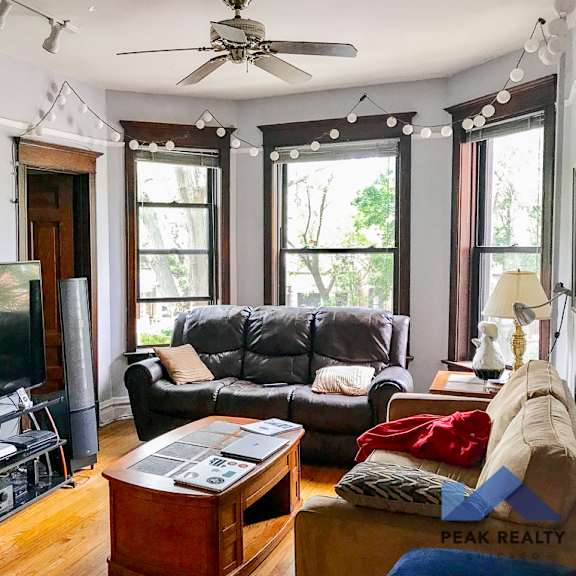 a living room with gray walls and a ceiling fan