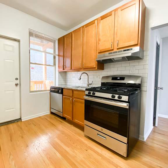a kitchen with wooden cabinets and a black stove top oven.