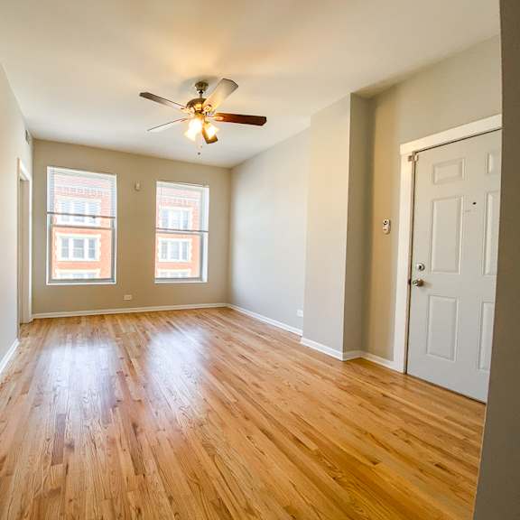 a room with wooden floors and a ceiling fan.