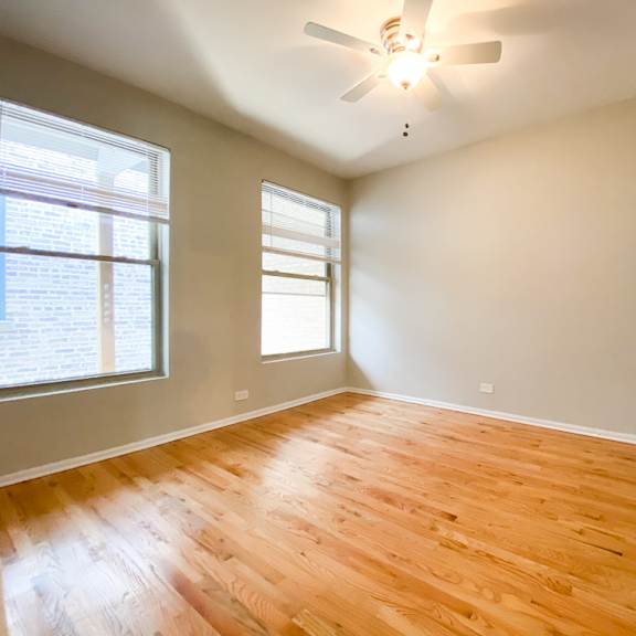 a room with wooden flooring and a ceiling fan.
