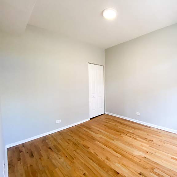 a room with wooden flooring and a white door.