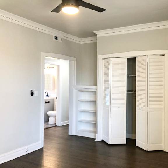 a room with a ceiling fan and a white door.