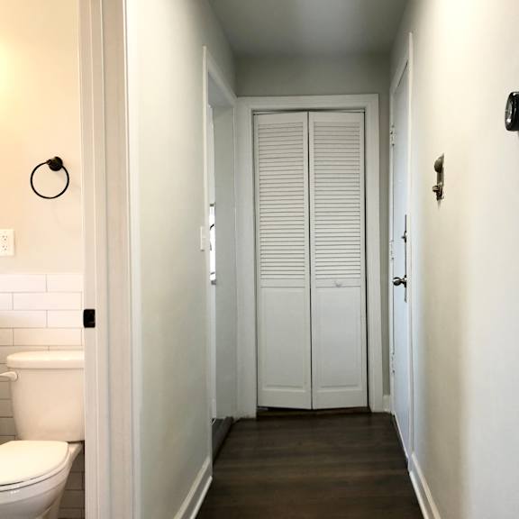 a white toilet is in a small bathroom with a white door.