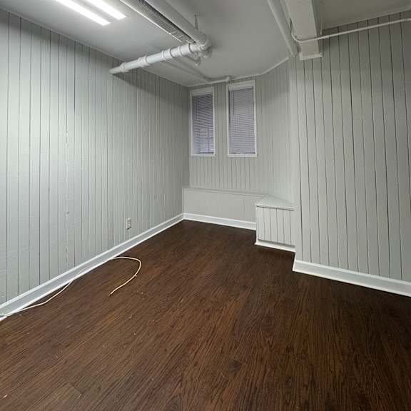 a white staircase with a wooden floor and a window.