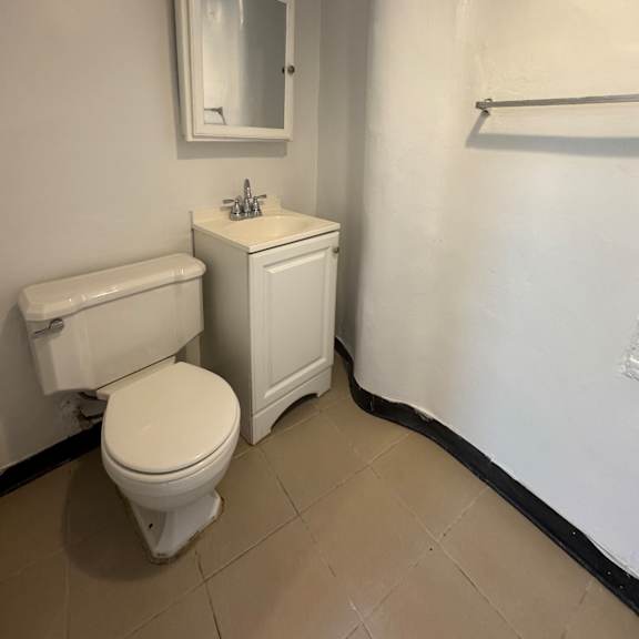 a white toilet and sink in a small bathroom.