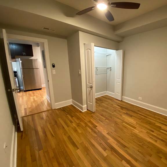 a room with wooden flooring and a ceiling fan.