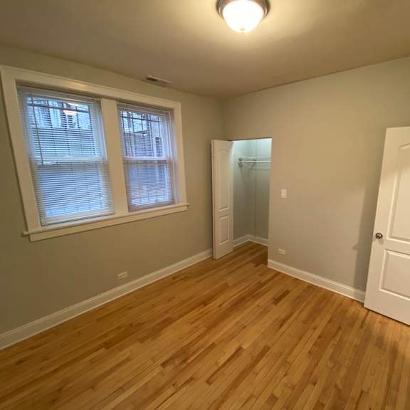 a room with wooden flooring and a white door.