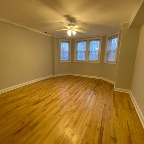 a room with wooden flooring and a ceiling fan.