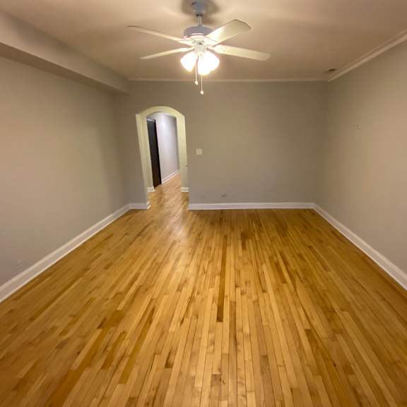 a room with wooden flooring and a ceiling fan.