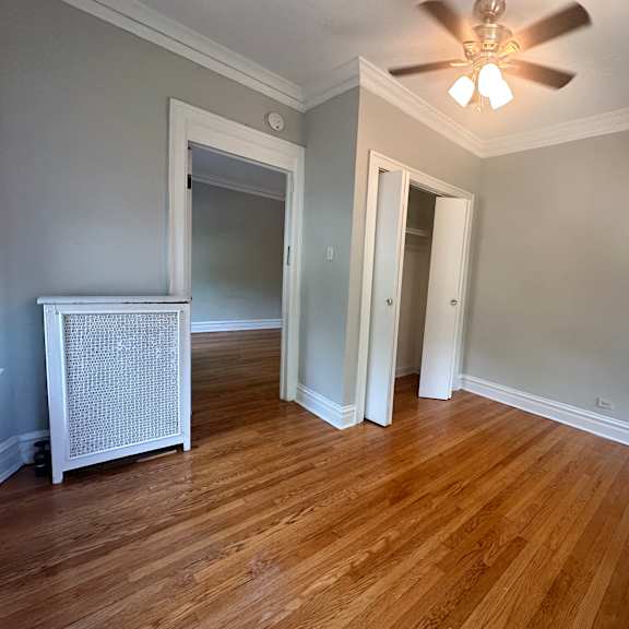 a living room with wood floors and a ceiling fan