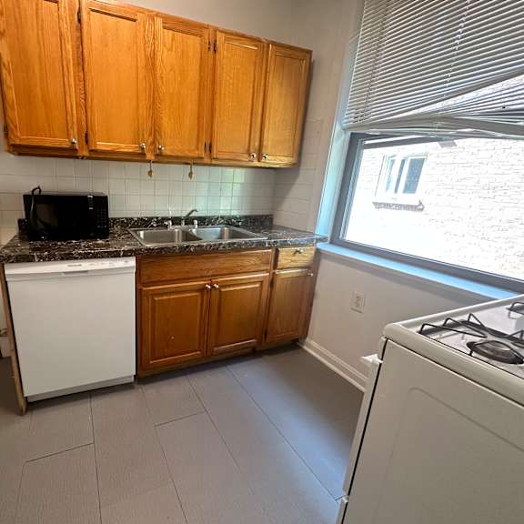 a small kitchen with white appliances and wooden cabinets