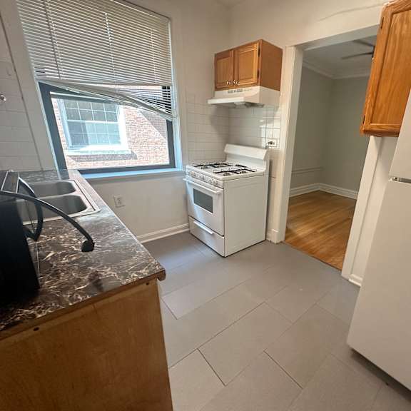 a kitchen with a stove refrigerator and a window