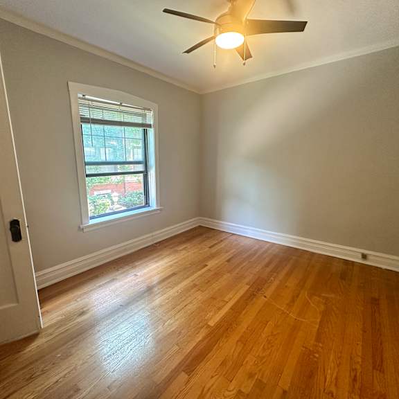a living room with wood floors and a ceiling fan