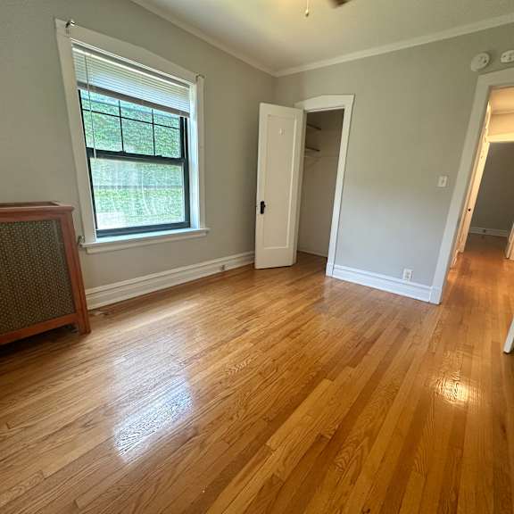 a living room with a hard wood floor and a large window