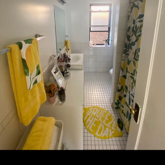 a bathroom with a yellow shower curtain and a toilet and a sink