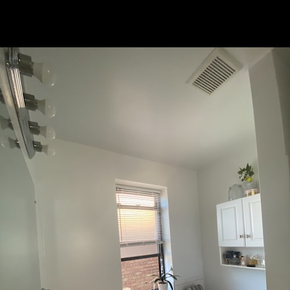 a bathroom with a toilet and a sink and a window