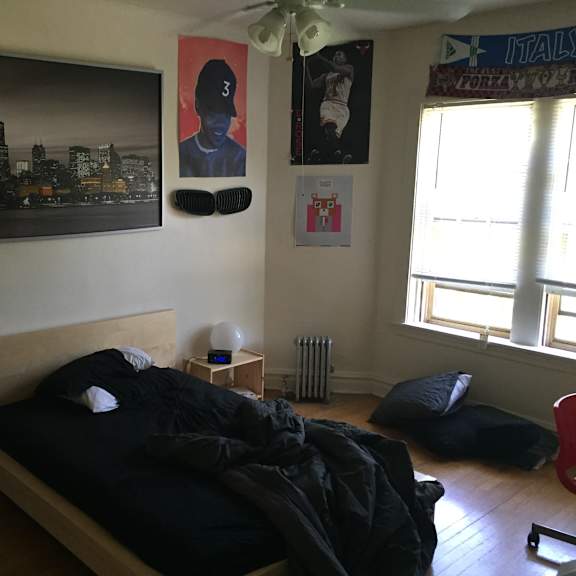 a bedroom with a bed and posters on the wall
