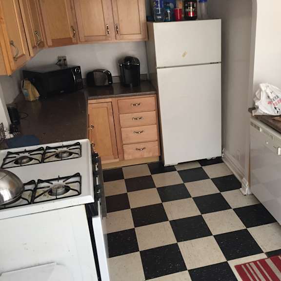 a kitchen with a checkered floor and a white refrigerator