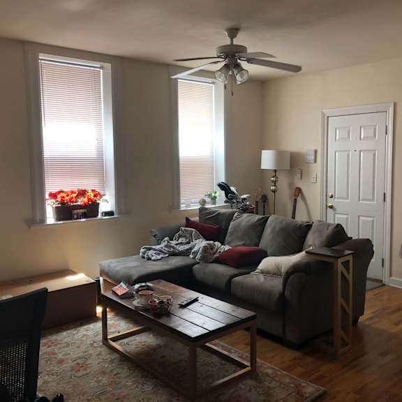 a living room with a grey couch and a wooden coffee table.