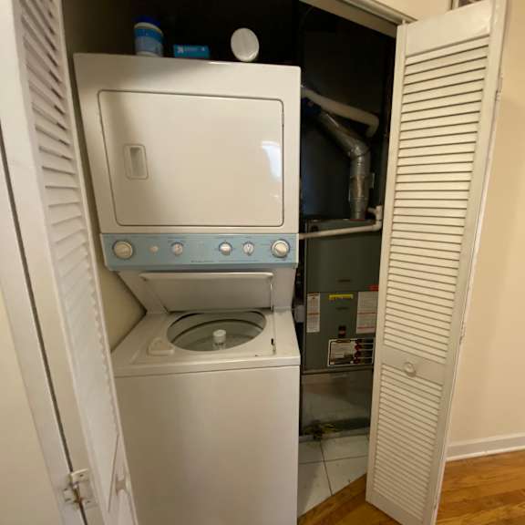 a white washing machine is installed in a small room.