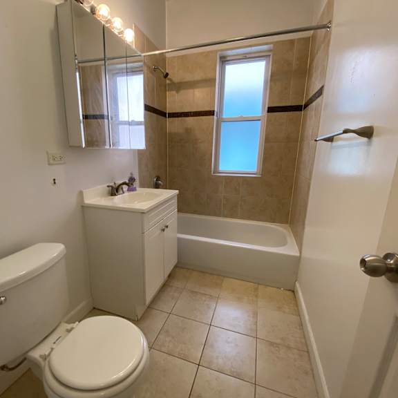 a white toilet sits next to a white sink in a bathroom.