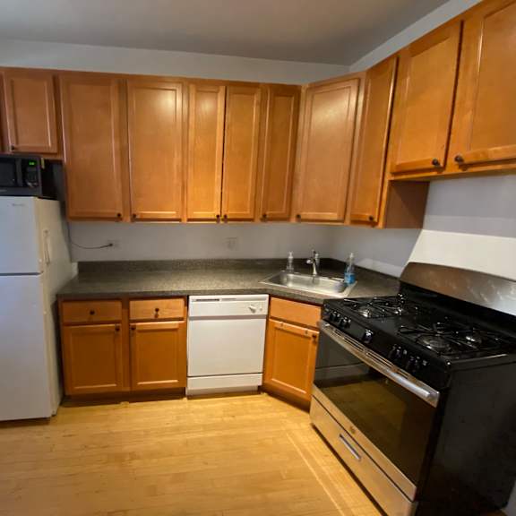 a kitchen with wooden cabinets and a white refrigerator.