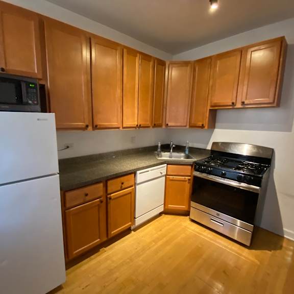 a kitchen with wooden cabinets and a white refrigerator.
