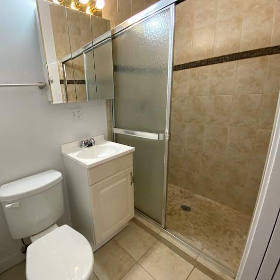 a white toilet sits next to a sink in a small bathroom.