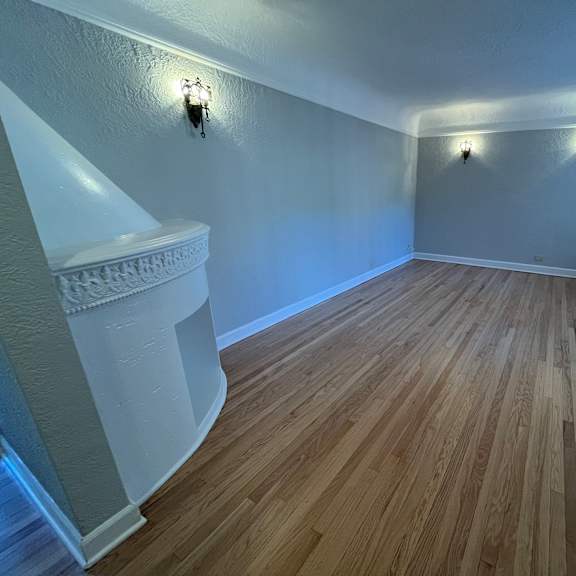 a room with wooden flooring and white walls.