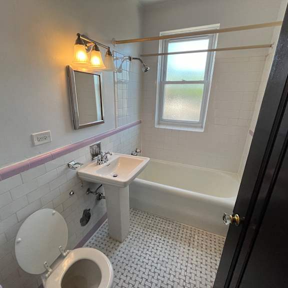 a bathroom with a toilet, sink, and bathtub.