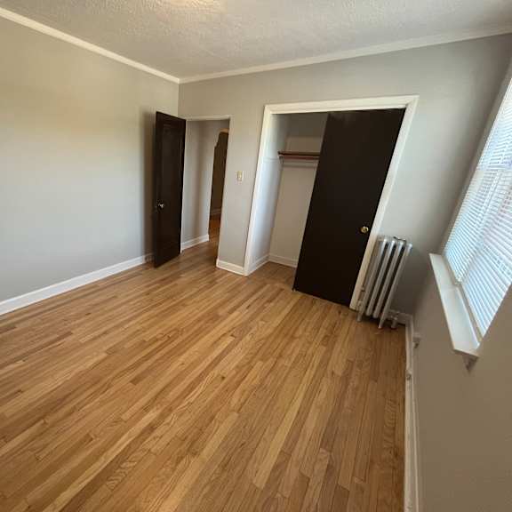 a room with wooden flooring and a black door.