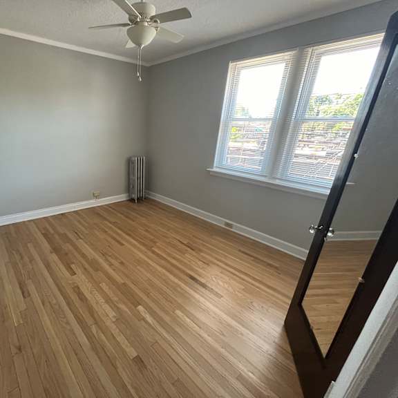a room with wooden flooring and a ceiling fan.