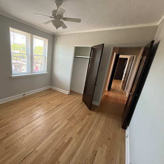 a room with wooden flooring and a ceiling fan.