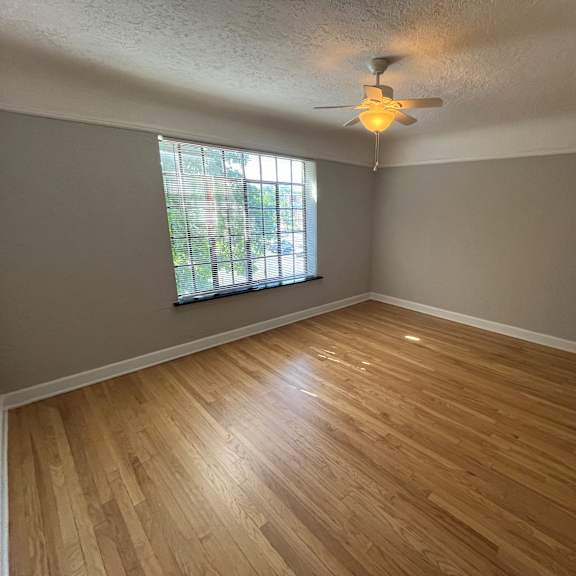 a room with wooden flooring and a ceiling fan.