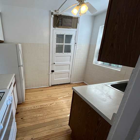 a kitchen with a white stove and wooden floors.