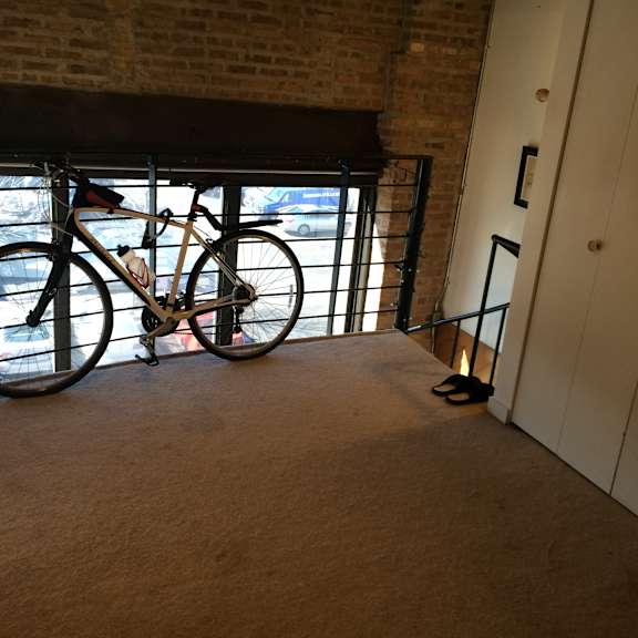 a bicycle is parked in a room with a brick wall.