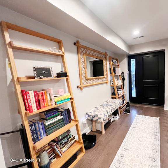 a room with a ladder, a mirror, a bench, and a bookshelf.
