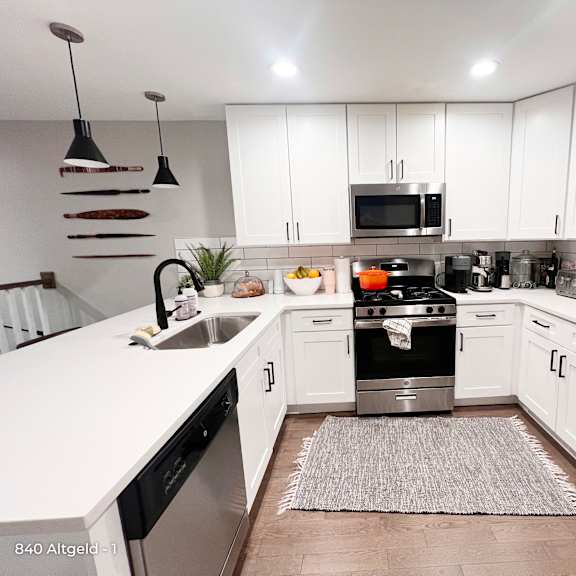 a modern kitchen with white cabinets and stainless steel appliances.