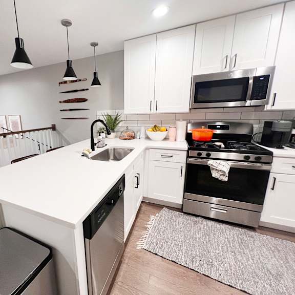 a modern kitchen with a white island and stainless steel appliances.